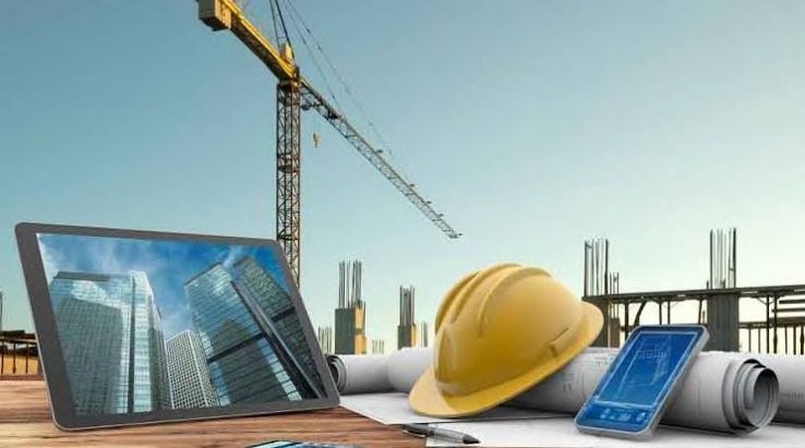 Hard hat, tablet and drawings on a construction site